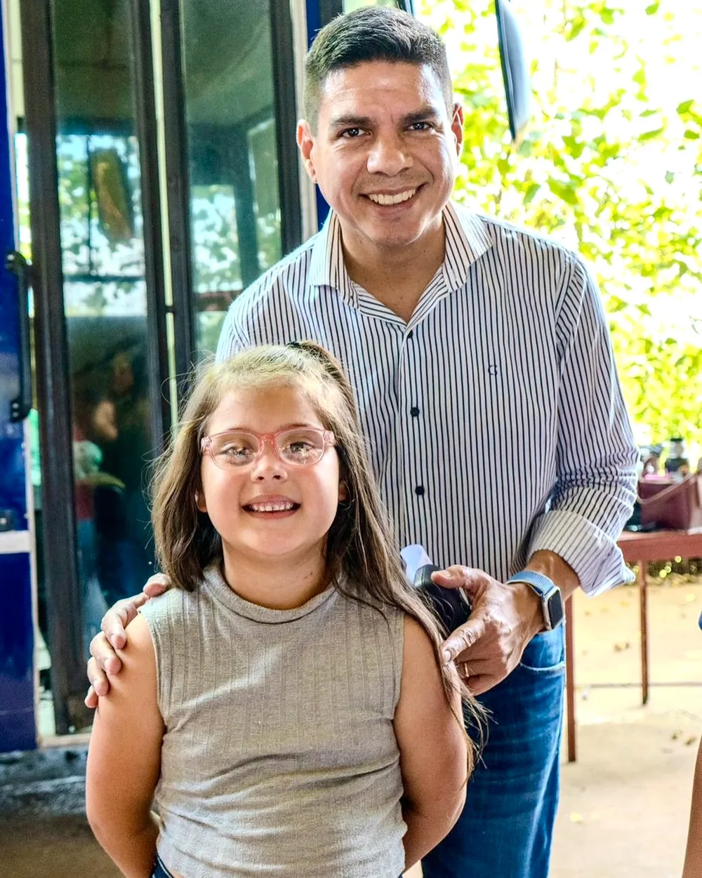 Una nena estrena sus lentes rosas nuevos y Fernando sonríe detrás
